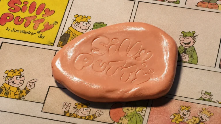 A ball of Silly Putty embossed with the Silly Putty logo, resting on a newspaper comics page.