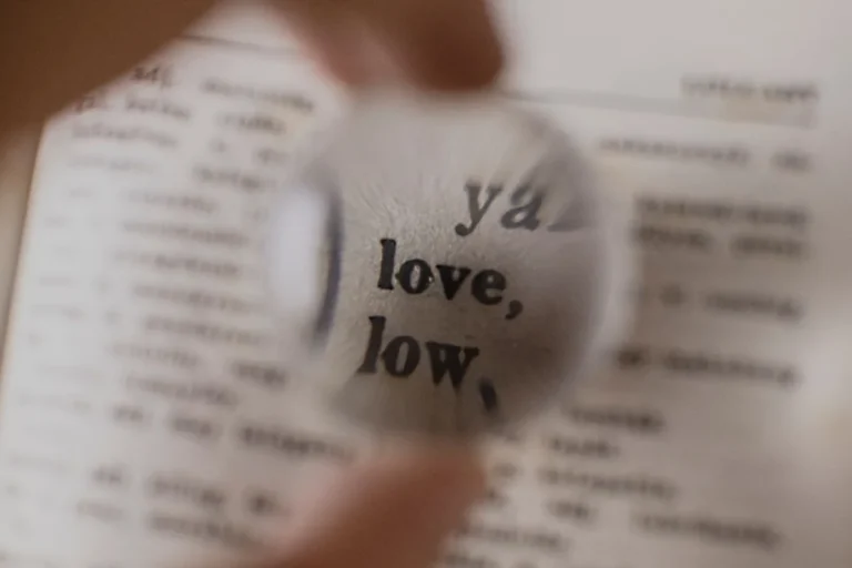 Antique dictionary pages under a magnifying glass