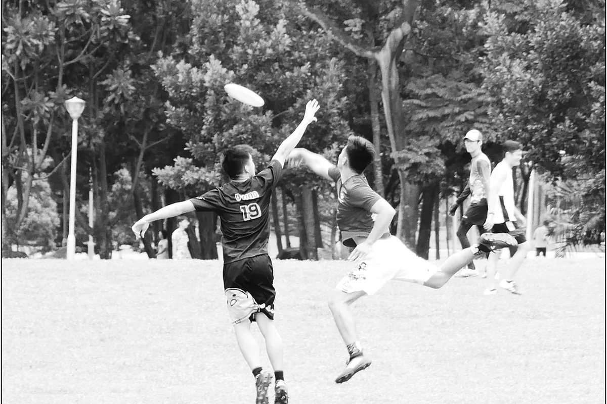 Players reaching for a flying disc in a park