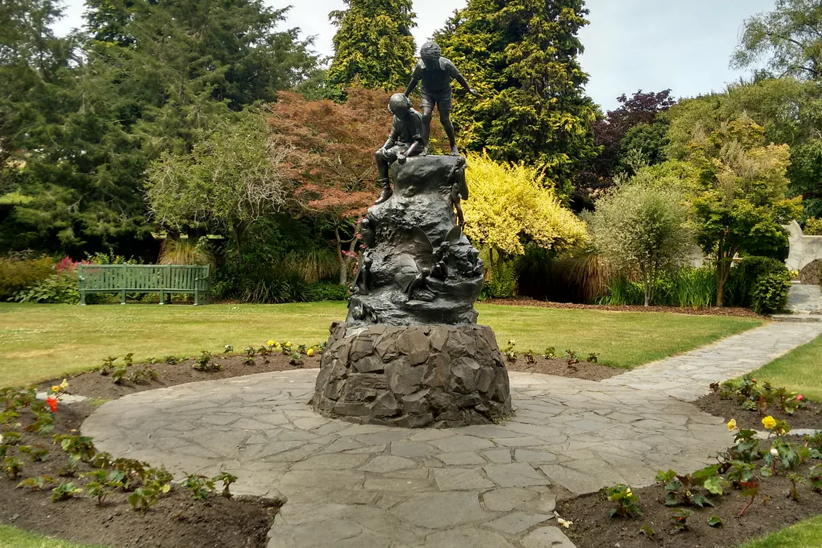 A statue of Peter Pan in a garden